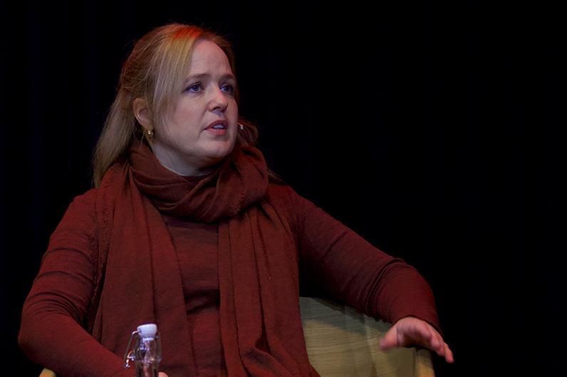 Dame snakker engasjert med mikrofon/mygg på øret