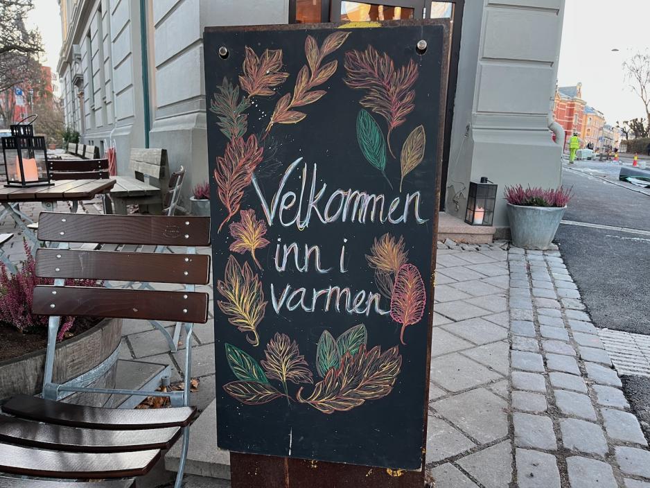 Skilt hvit det står "Velkommen inn", utenfor Åpent Bakeri på Frogner