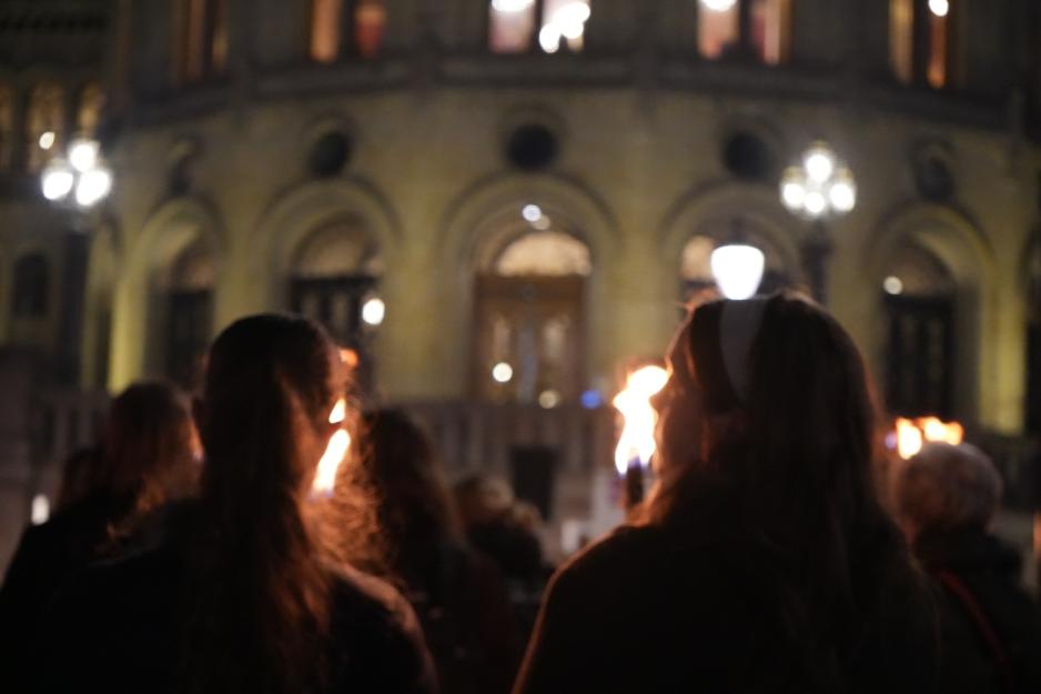 To jenter som står med fakkel i markeringen. 