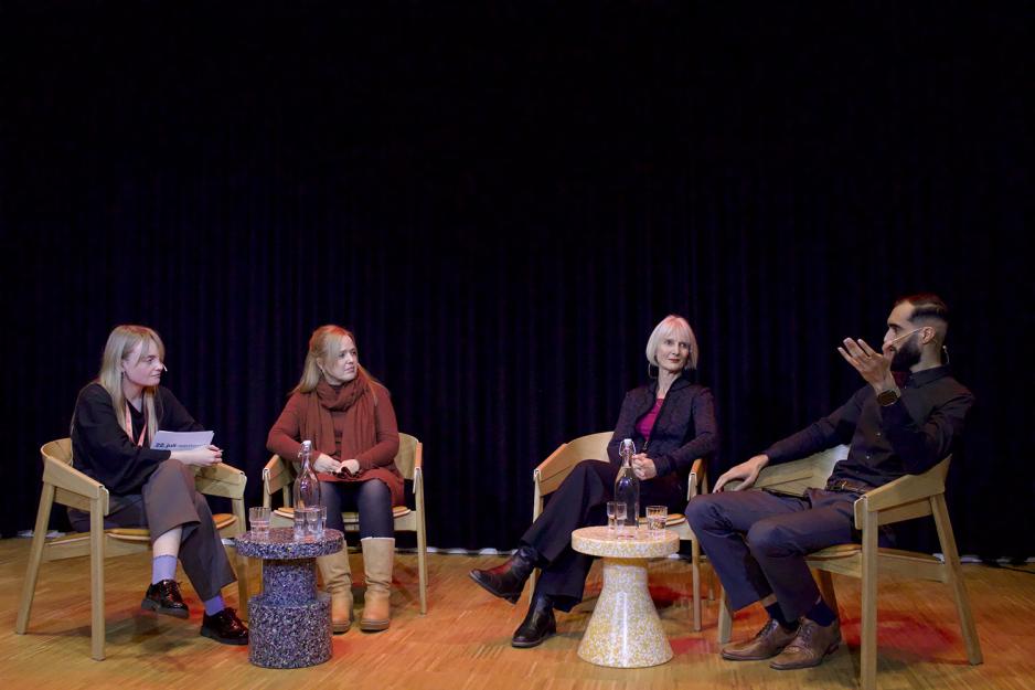 Fire mennesker snakker sammen på en scene