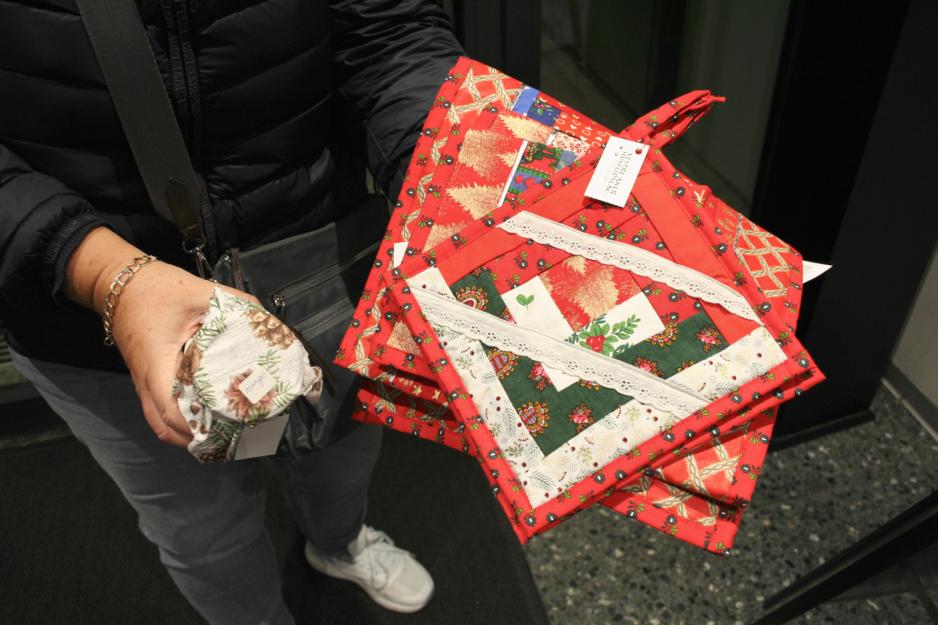 Kunde viser frem hjemmelagde grytekluter, syltetøy og løpere fra Vestre Aker Husflidslags julemarked