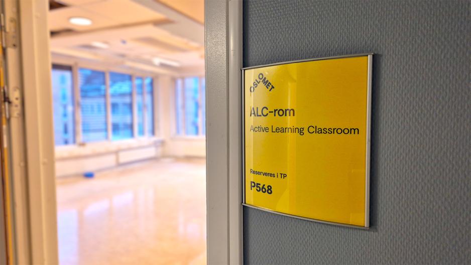 Gult skilt utenfor et rom i OsloMet, P48. P&aring; skiltet st&aring;r det "ALC-rom. Active Learning Classrom. Reserveres i TP. Rom P568".