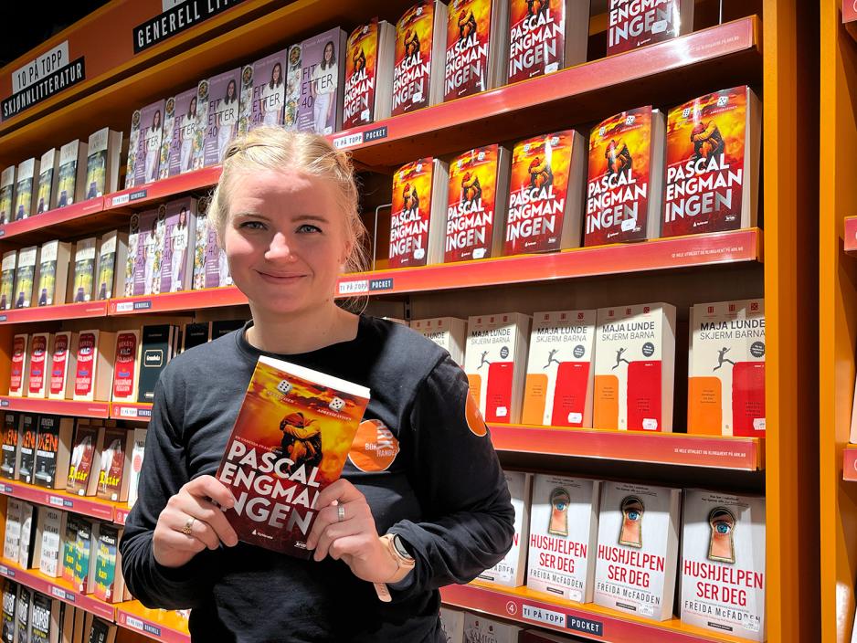 Frida Gulichsen holder opp en bok av Pascal Engman.