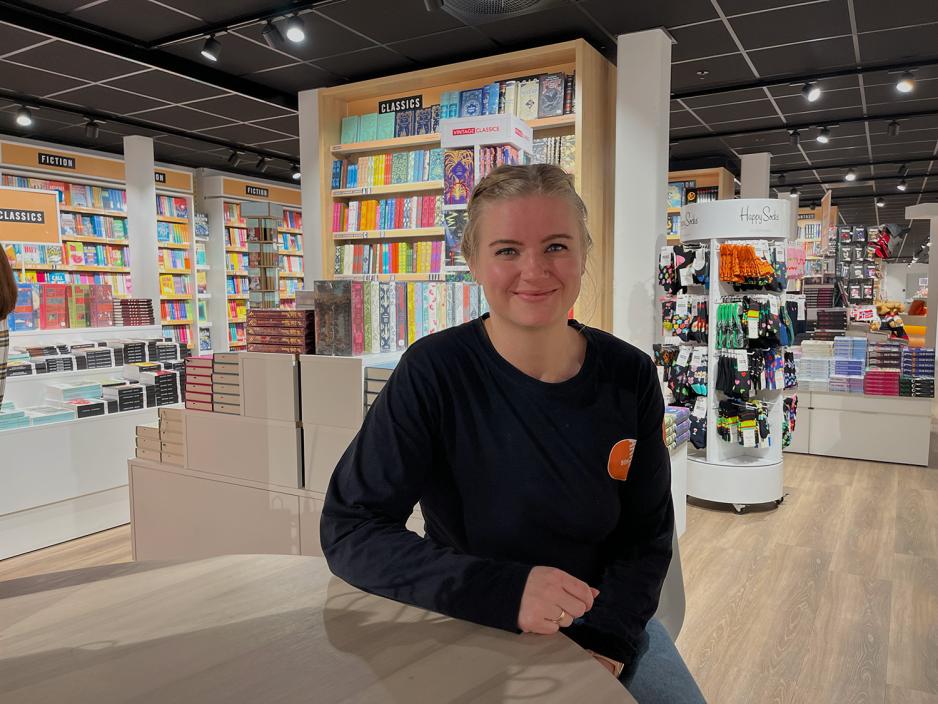 Frida Gulichsen sitter ved et bord og smiler. 