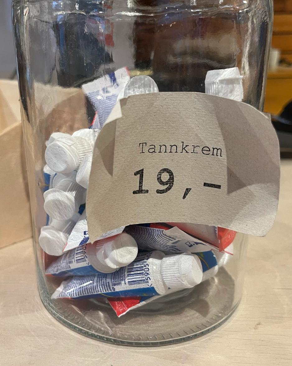 En krukke med tannkrem i reisest&oslash;rrelse og en lapp hvor det st&aring;r "tannkrem 19,-"