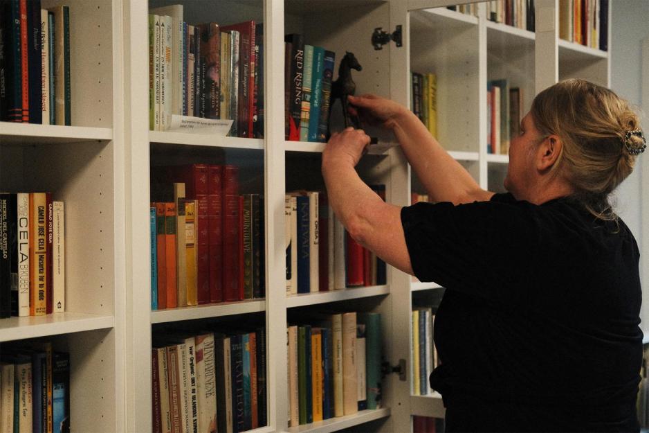 Hilde Lyng ser i bokhylle