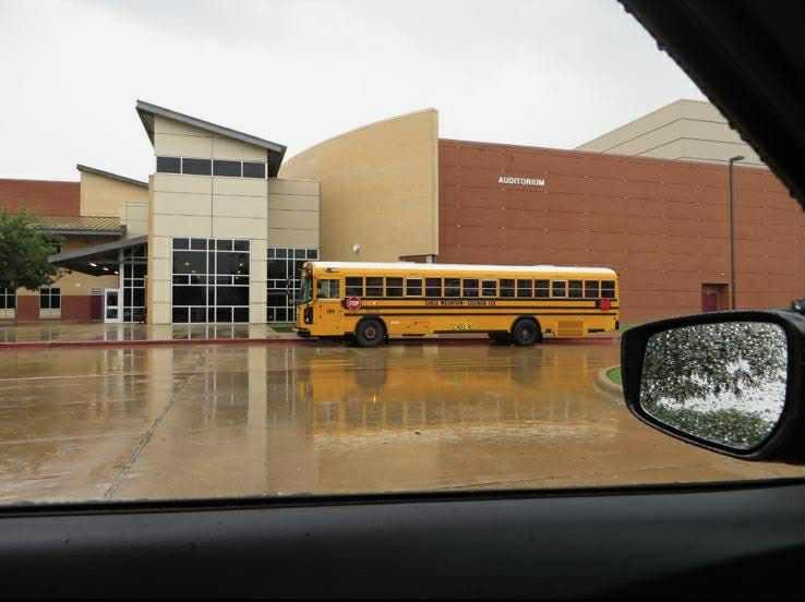 En amerikansk high school med en skolebuss utenfor