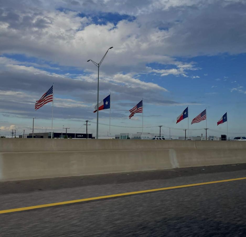 Amerikanske flagg og Texas' flagg langs veien