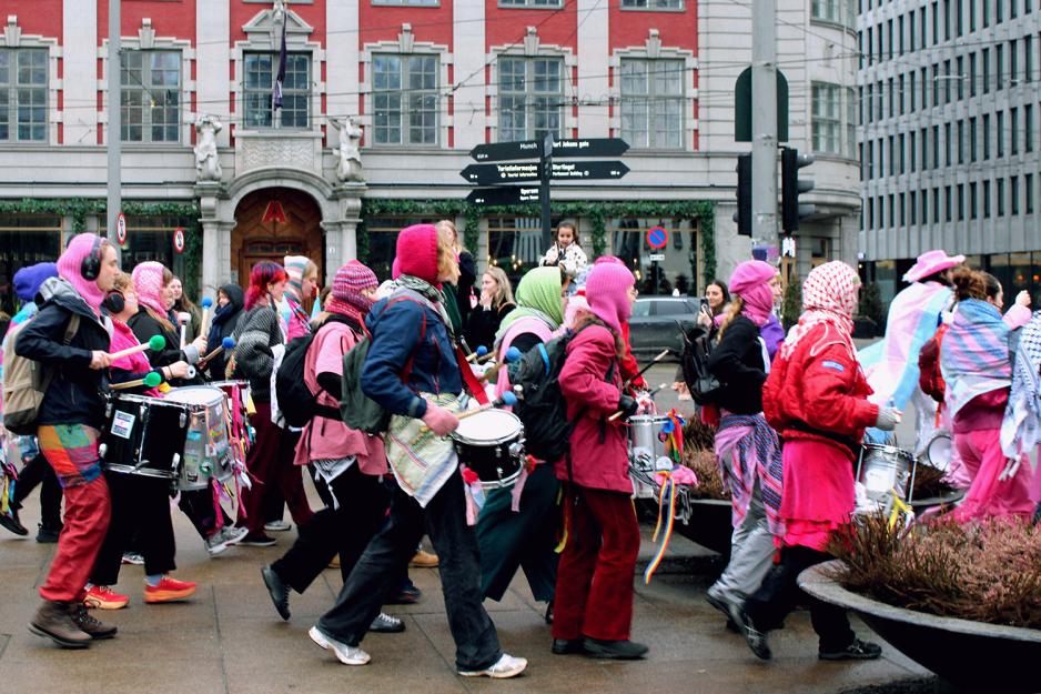 Korpset fra det inkluderende 8. mars toget g&aring;r forbi ikledd alle regnbuens farger