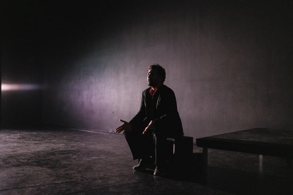 Skuespiller Kadir Talabani sittende p&aring; scenen under forestilling.