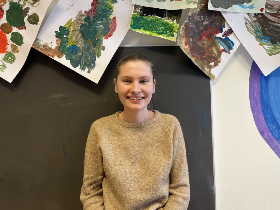 Pedagogisk leder i Mortensrud barnehage med bilder i bakgrunnen