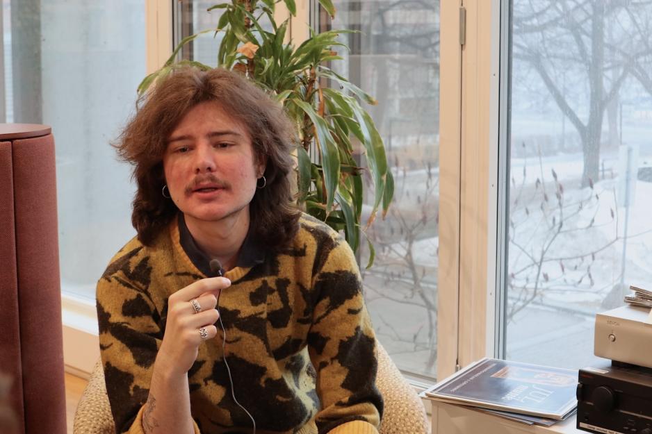 Laban sitter i en stol og blir intervjuet med myggen i h&aring;nda. 