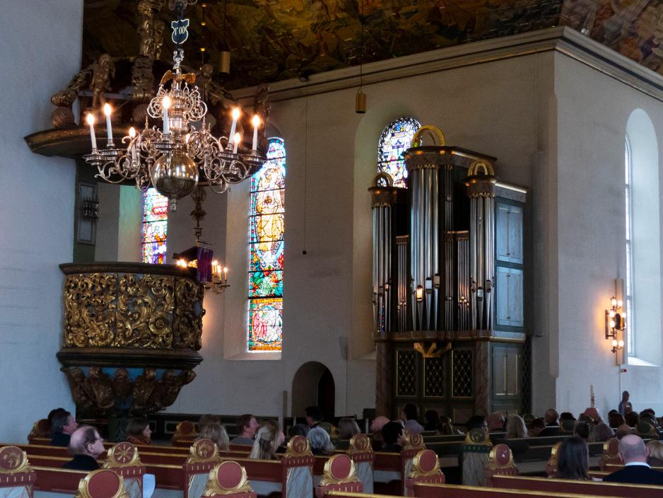 Bildet er tatt i Oslo domkirke, fra et hj&oslash;rne i salen. Viser publikum som sitter i benkene, prekestolen og kororgel.
