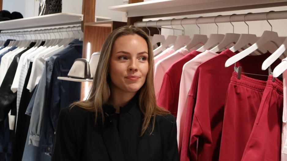 Ansatt p&aring; Camillia Phil st&aring;r foran en rekke rosa plagg.