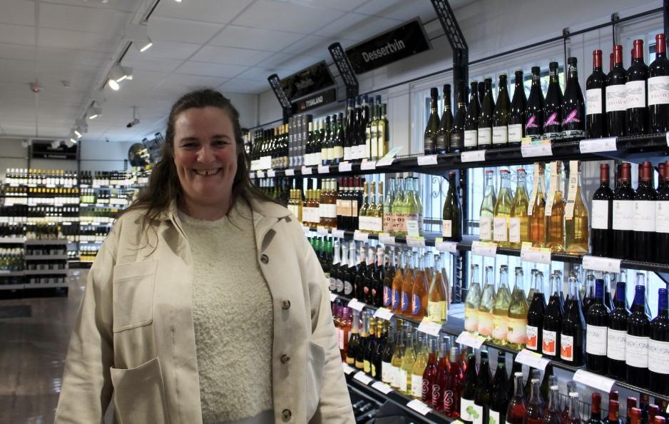 Anne Engrav foran hyllene p&aring; vinmonopolet