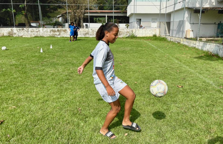 Camilly trikser med en fotball p&aring; en fotballbane. 
