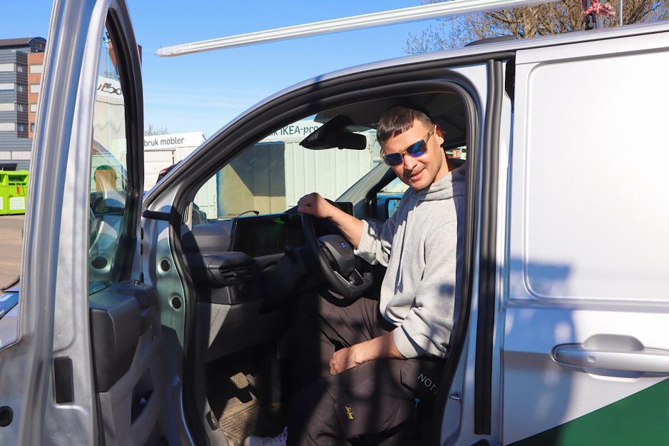 Mann sitter i bil med solbriller.