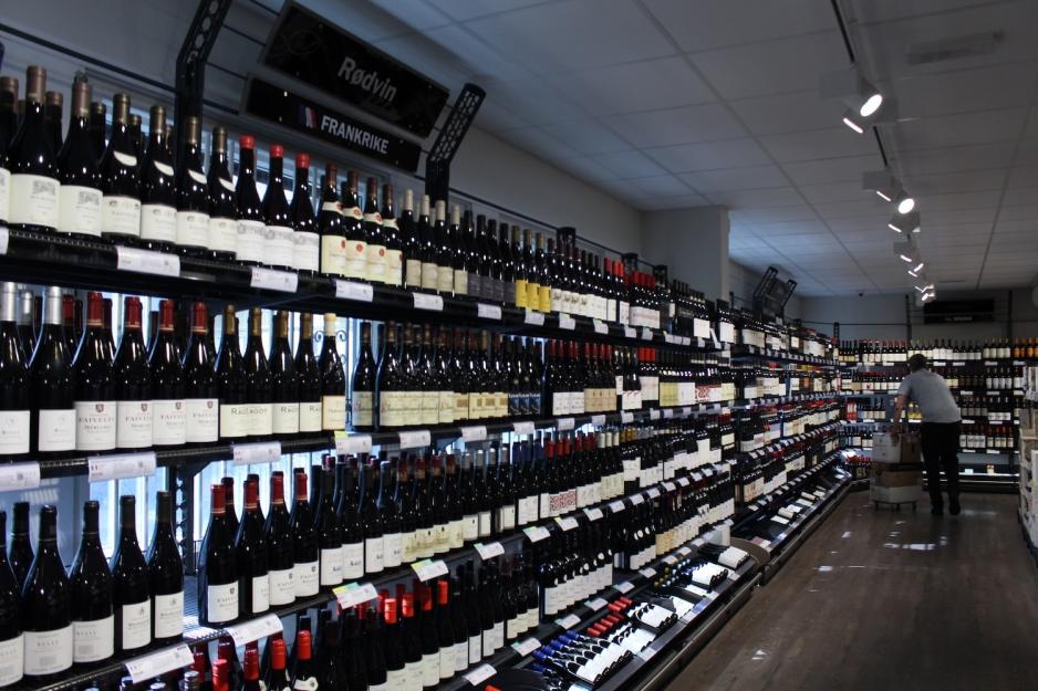 Et oversiktsbilde av et Vinmonopol der man ser ulike r&oslash;dvinsflasker.