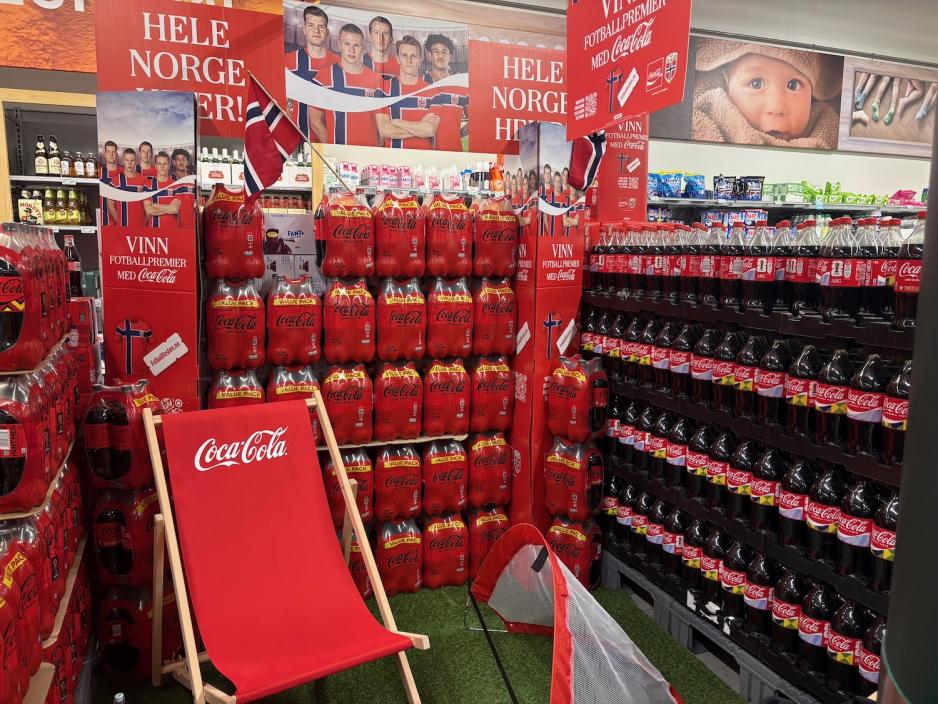 Hyller med Coca-Cola-flasker som markedsf&oslash;res med fotballandslaget