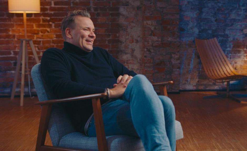 Aslak Klever sitter med et bredt smil i en stol