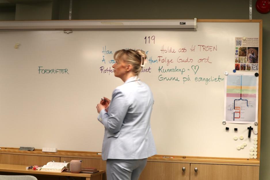 Beate står foran tavla og skriver forskrifter 