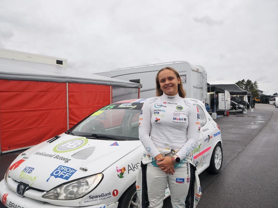 Isabell står foran bilen sin