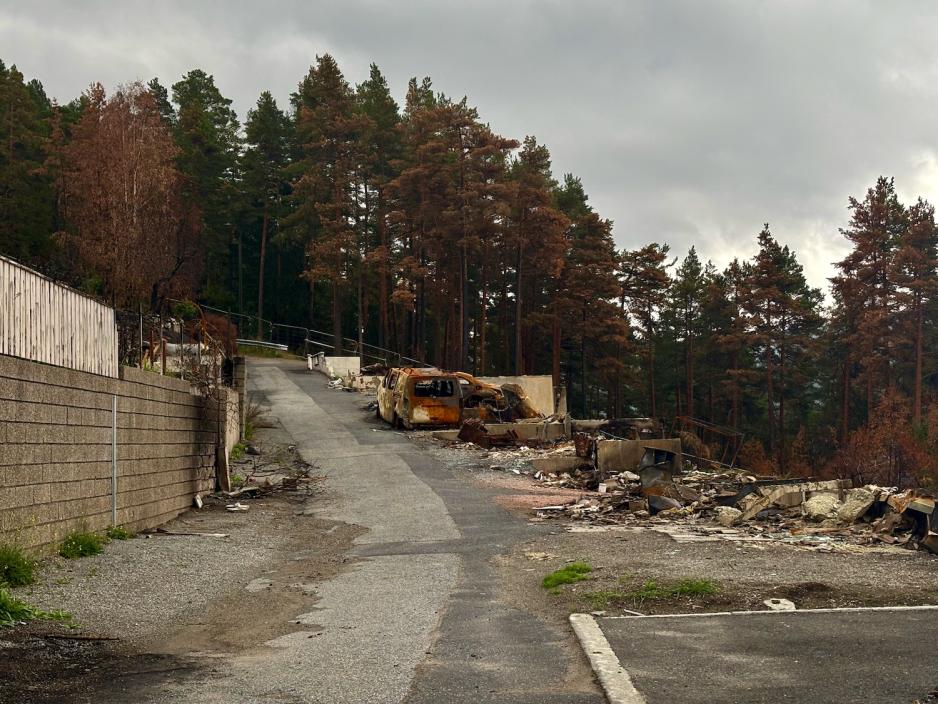 Utbrent gate, en helt &oslash;delagt bil i midten av bildet.