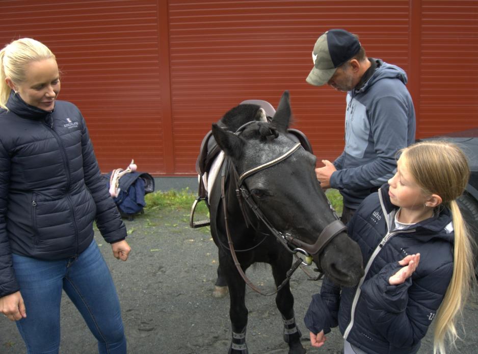 Foreldre og datter saler på ponni