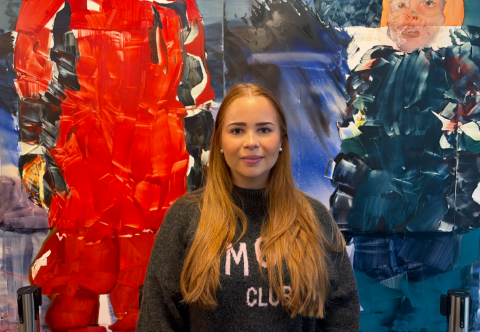Anna st&aring;r foran et maleri p&aring; OsloMet 