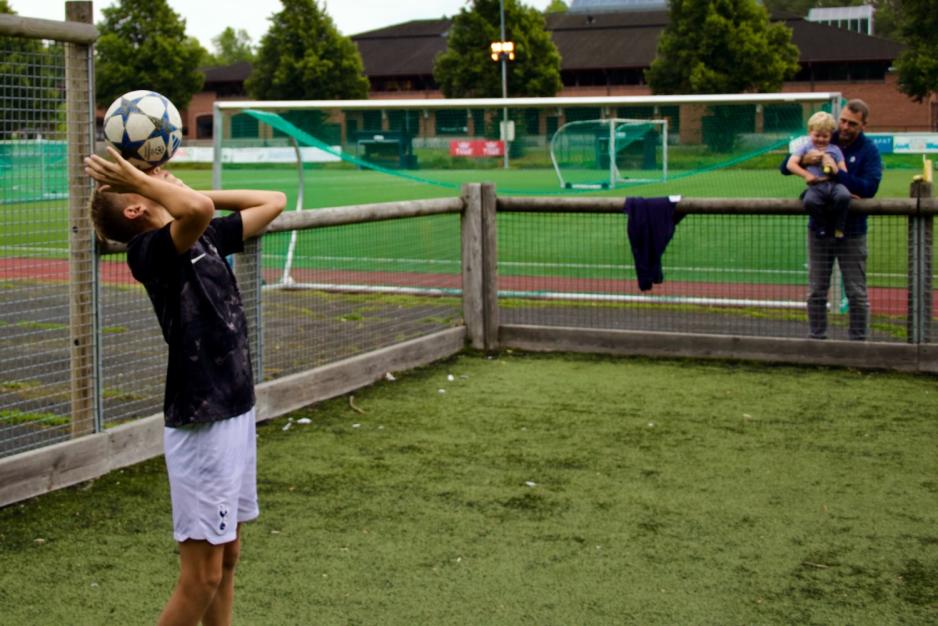 Kaspian trikser mens pappa og lillebror ser på
