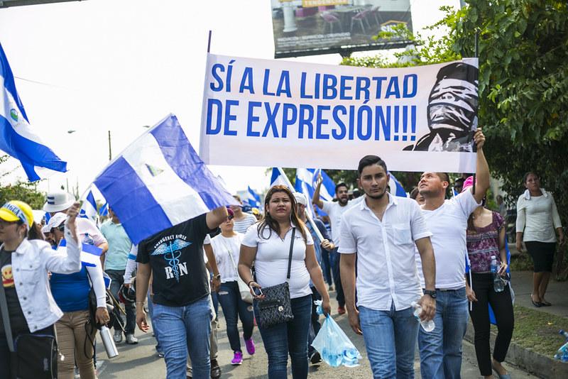 Demonstranter i Nicaragua holder opp flagg og bannere