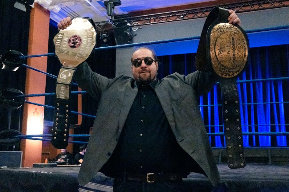 Wrestler Bjørn Sem foran ringen og holder to belter