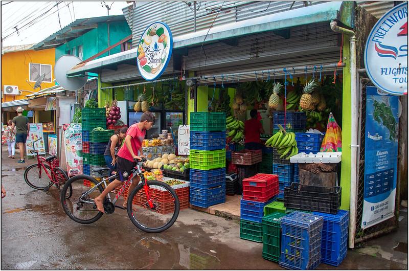 En gutt på sykkel titter på bananer til salgs i Costa Rica 