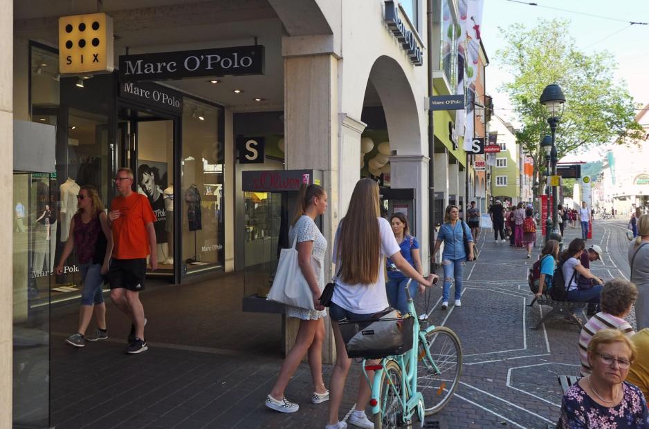 To unge jenter går ut i handlegaten utenfor en av den svenske fashionbutikken Marc O'Polos filialer.