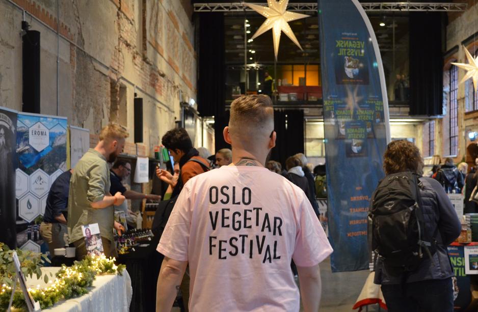 mann i rosa genser går med en t-skjorte hvor det står Oslo Vegetarfestival.