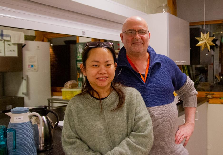 Et par står smilende mot kamera. Kvinnen står lengst frem, med svart hår og briller på hodet. Mannen bak er skallet, med briller.