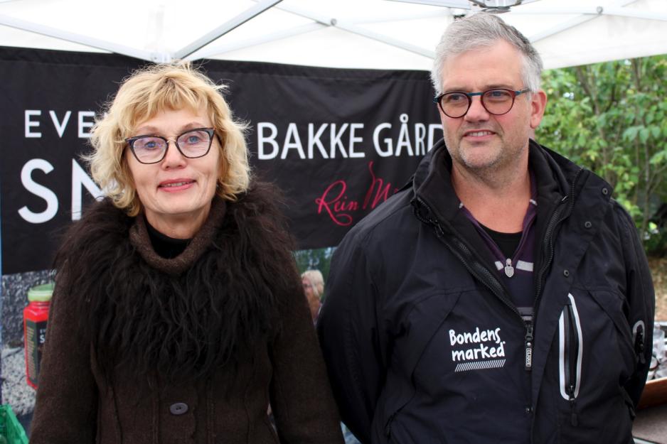 Bilde av Anne Karin Bøhn og Svein Indresæter som står foran boden deres på Bondens marked. 