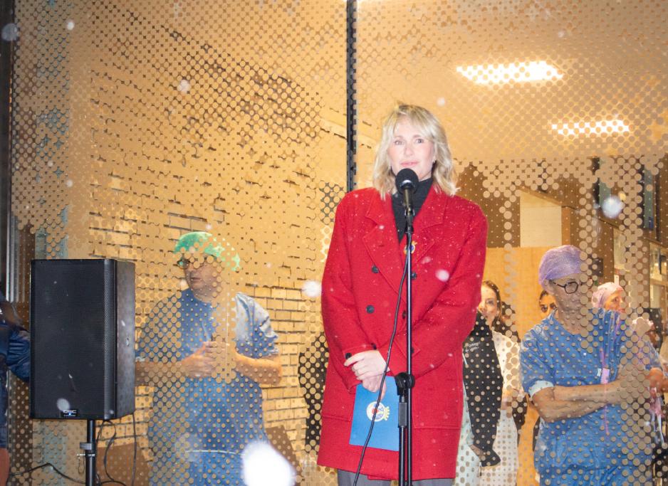 Ordfører Anne Lindboe fra Høyre sa noen ord foran inngangen til legevaktbygget. Hun står på en talerstol. Bak henne er en gjennomsiktig vindusrute. Du kan se at det står helsepersonell inne i bygget.