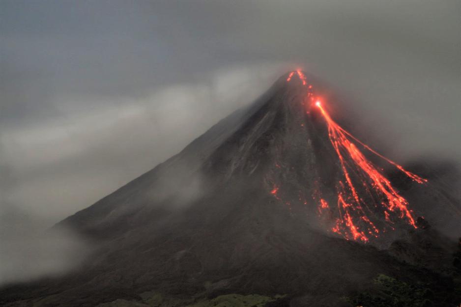 Den aktive vulkanen Arenal i Costa Rica. Lava flommer nedover fjellsidene, mens røyken stiger til værs.