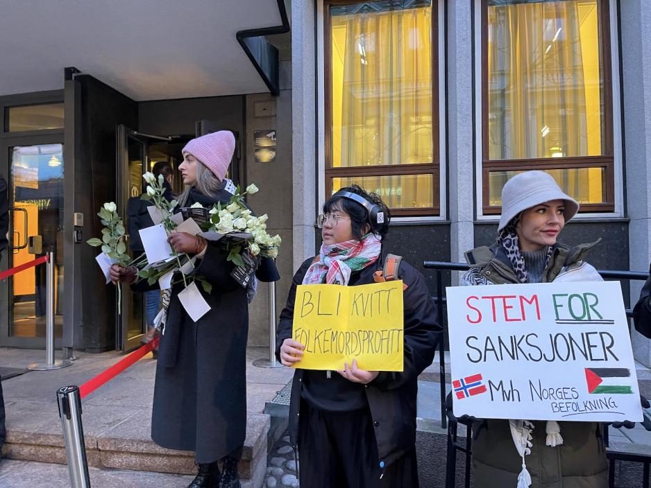 Demonstranter foran Stortinget med palestinske flagg og roser. 