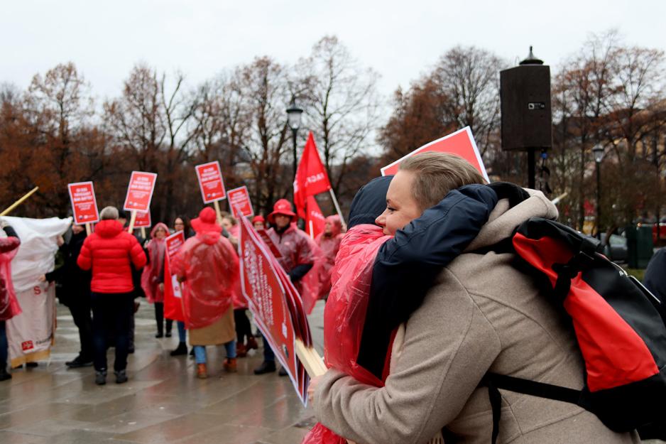 To damer som klemmer under demonstrasjon. 