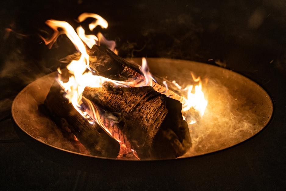 Vedkubbe som brenner i en bålpanne