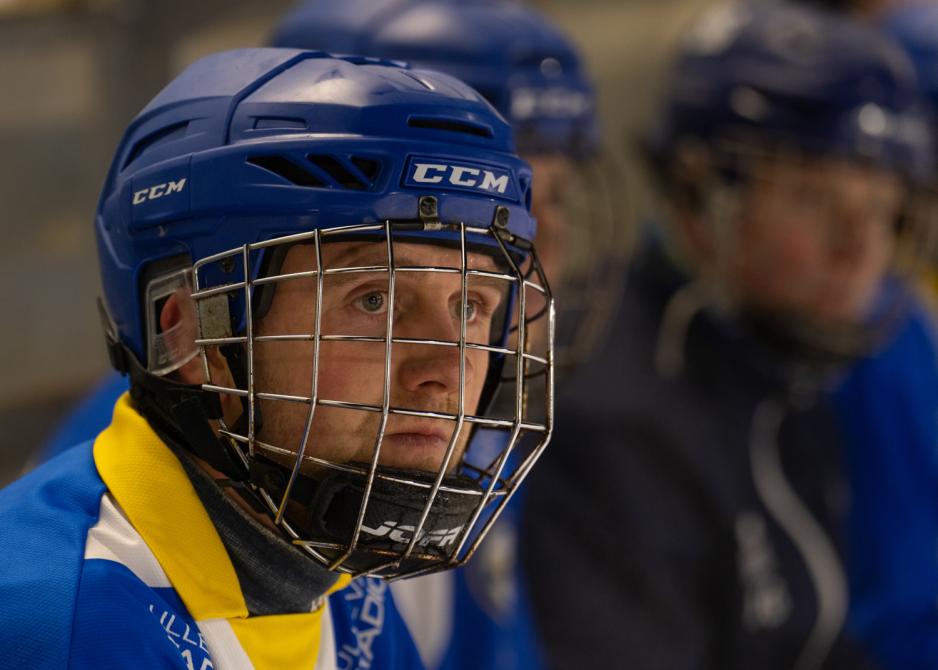 Bandyspiller Ola Gundersen Skåre med hjelm på benk