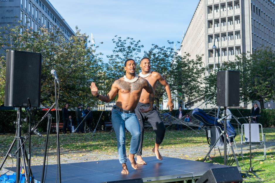 To menn står på en scene og danser synkront