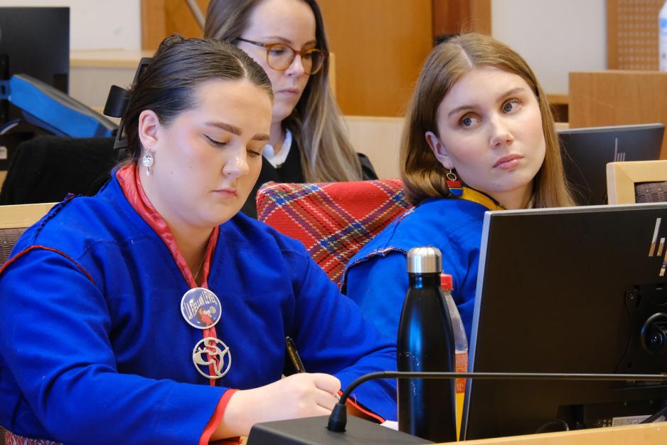 Elle Nystad og Ella Marie Hætta Isaksen sitter i rettssak. Hætta Isaksen ser mot tut i rommet, mens Nystad ser ned i bordet og holder en penn. 