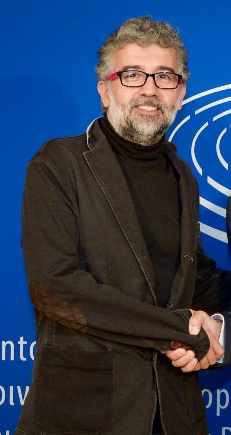 Erol Onderoglu framfor blå vegg. 