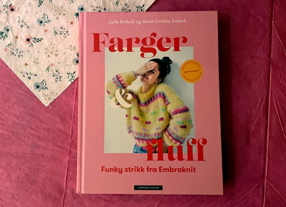 Bildet viser omslaget til strikkeboken "Farger og fluff" av Julie og Anne-Grethe Embrå. Omslaget er rosa. 