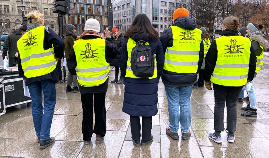 mennesker som  står i gule vester