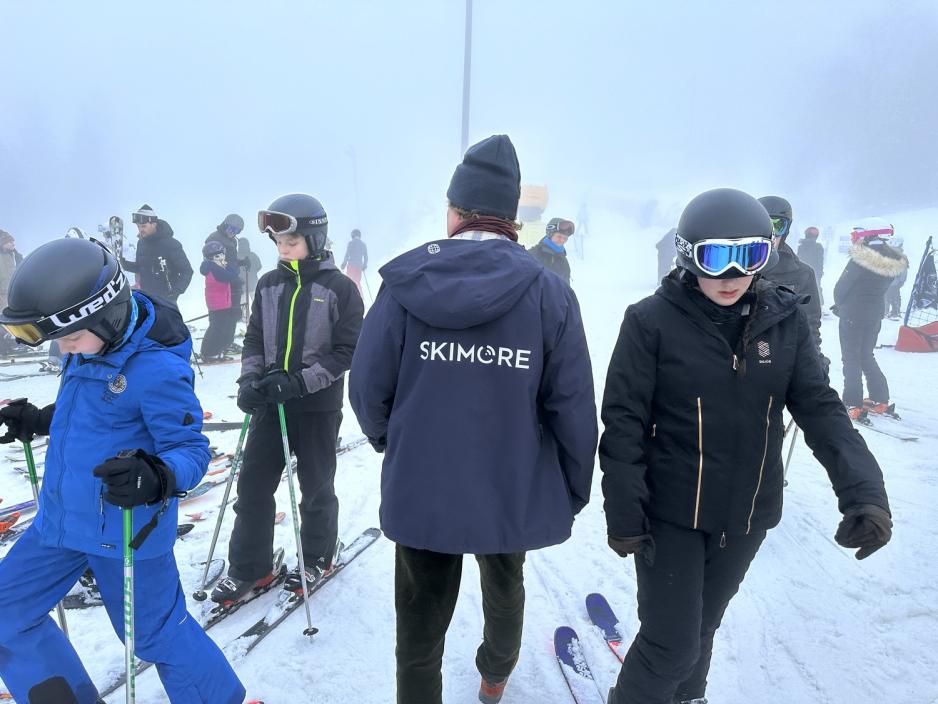 Mann med folk rundt på skianlegg