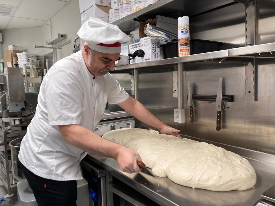 Inne på kjøkkenet i Trattoria Crudo lager Francesco De Palma en stor pizzadeig. 